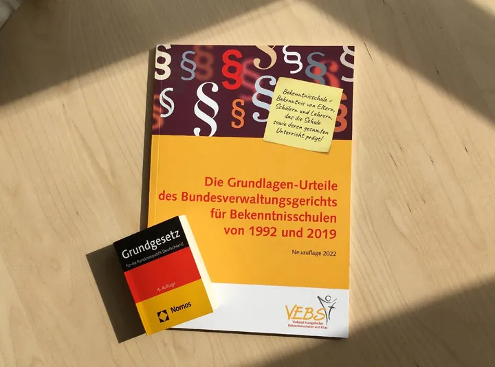 Broschüre des VEBS „Die Grundlagen-Urteile des Bundesverwaltungsgerichts für Bekenntnisschulen von 1992 und 2019“, Neuauflage 2022, daneben eine Ausgabe des Grundgesetzes