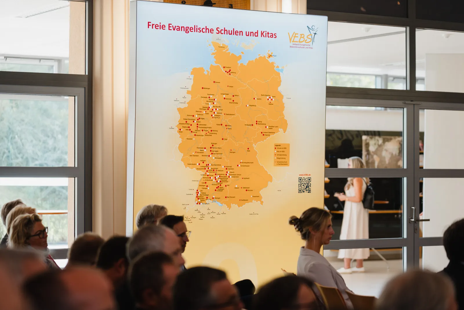 Große Deutschlandkarte der Freien Evangelischen Schulen und Kitas im VEBS, im Vordergrund Gäste