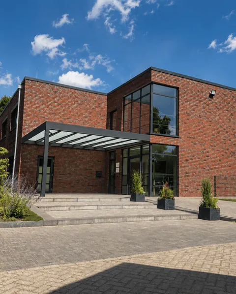 Neues Schulgebäude aus rotem Backstein mit großer Glasfront und breitem Eingangsbereich